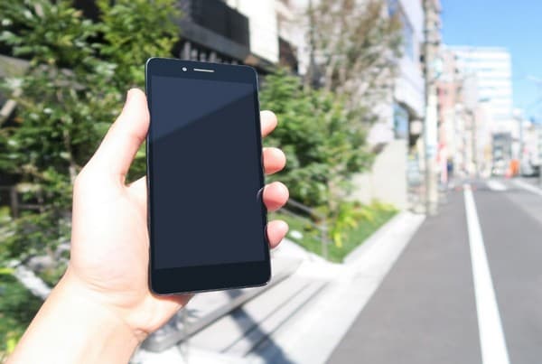 スマホを持ち、見ながら歩く画像のイメージ